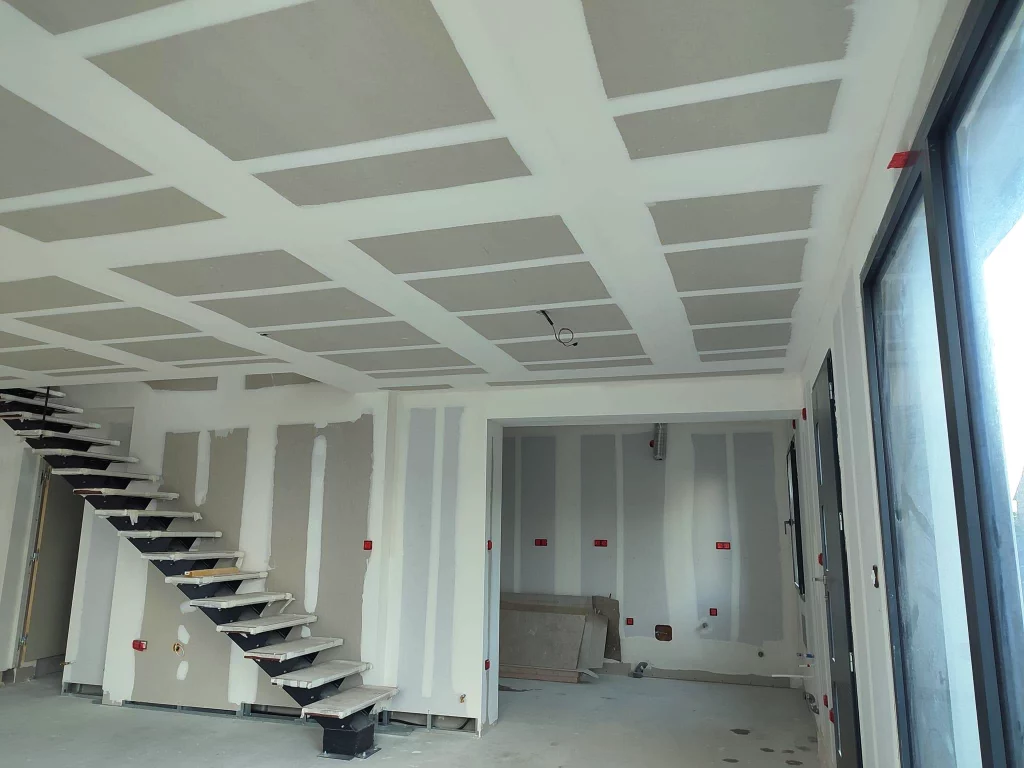 cloison et placoplâtre au plafond dans un salon avec escalier